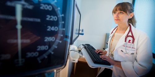 Woman in lab coat at computer