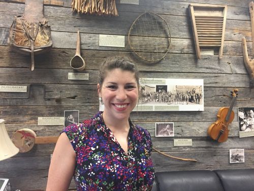 Woman standing in front of museum wall.