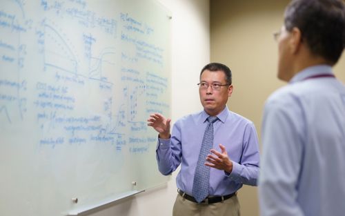 photo of Chia-ho Hua at white board with co-worker