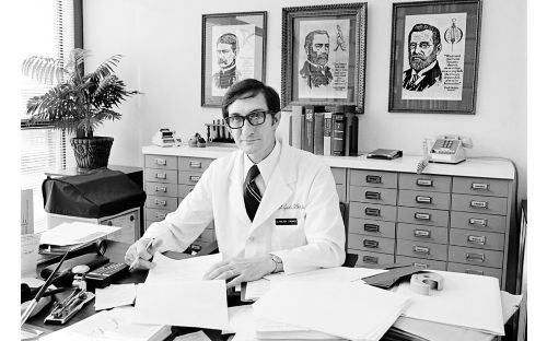 Walter Hughes sits at a desk early in his career