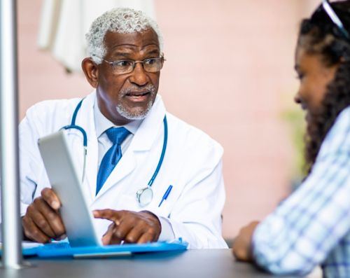 Male doctor speaking with female patient