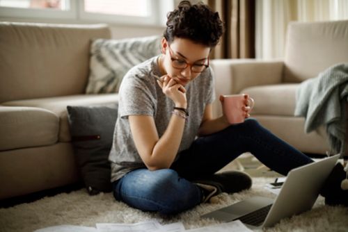 Person sitting on the floor looking at a computer