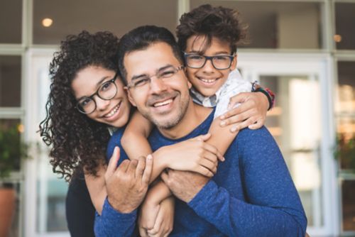 Hispanic family with father, son, and daughter wearing glasses.