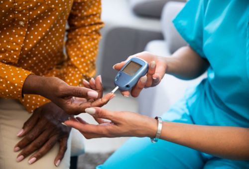 A nurse taking blood sugar of a patient