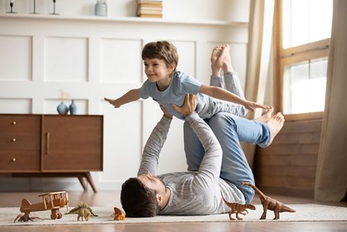 photo of dad playing with child doing "airplane" 