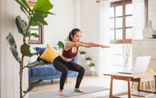 Woman doing a squat on yoga mat