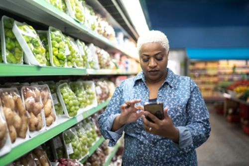 Woman in produce aisle of grocery store 