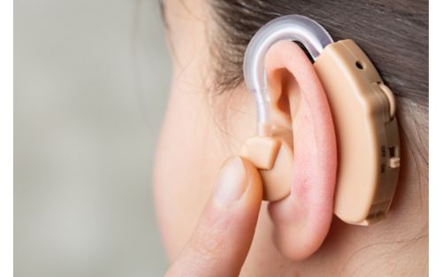 A close-up of a hearing aid in a woman's ear