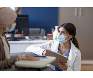 Young female doctor talks with patient in clinical setting