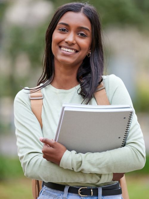 photo of young woman holding textbooks
