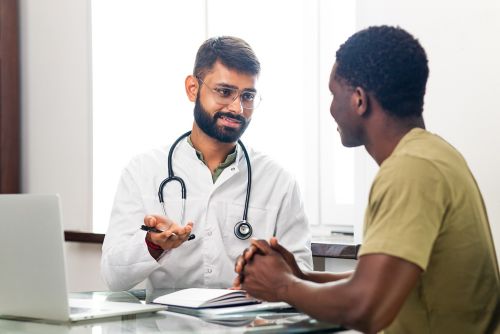 Male doctor speaking with male patient