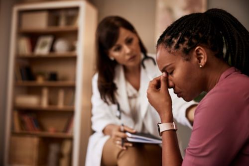 Depressed looking woman speaking with female doctor
