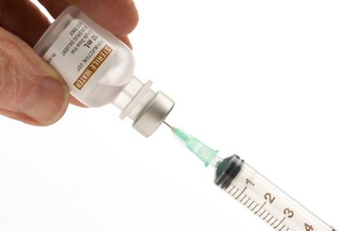 Withdrawing sterile water to add to medication.