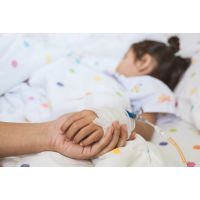 Photo of Parent holding sick child's hand