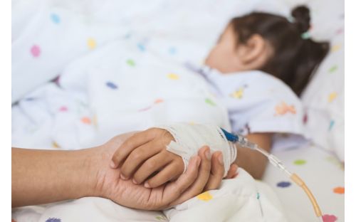 Photo of Parent holding sick child's hand