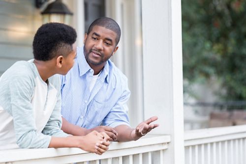 Pai e filho em uma conversa séria na varanda.