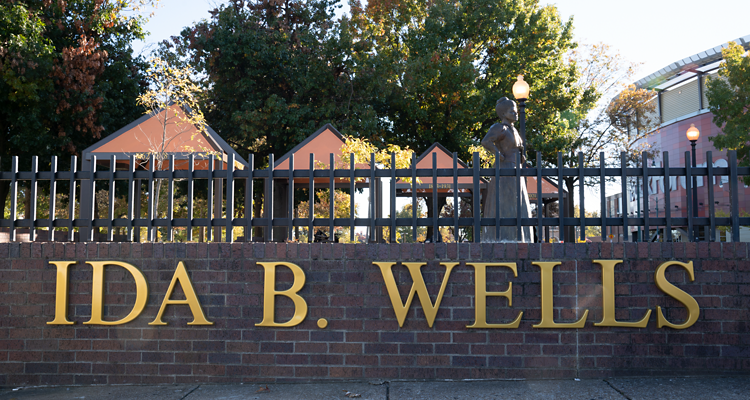 Ida B. Wells entrance park with statue behind fence