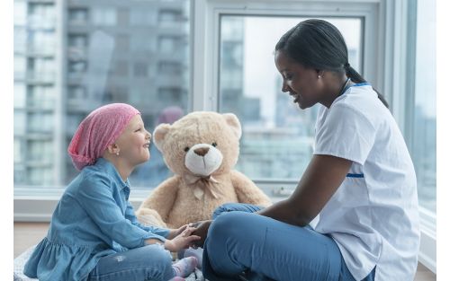 Child cancer patient playing with nurse 