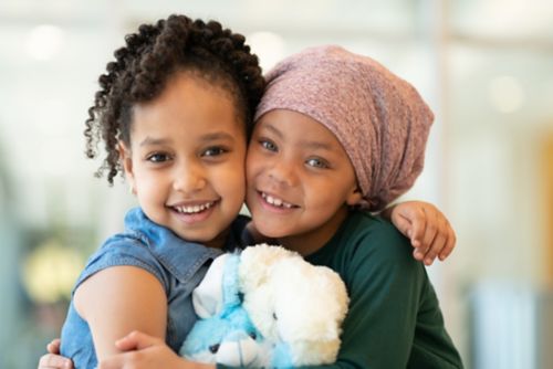 Two little girls hugging and smiling