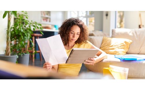 Woman checking her finances on ipad at home