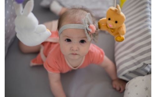 stock photo of baby in crib looking up at camera