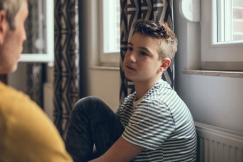 Un adolescente habla con un adulto