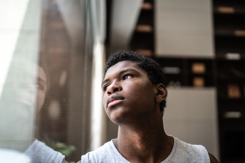 photo of young man, sad,  looking out the window