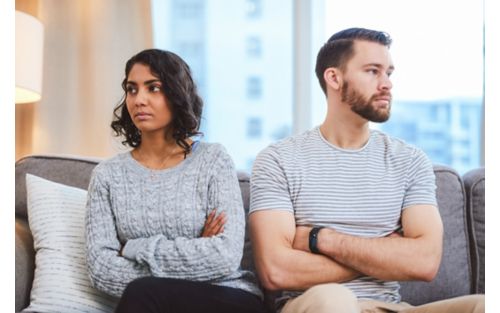 Young couple turning away from each other with arms crossed