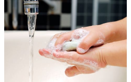 Child washing hands with soap and water