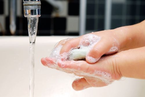 Close up of child washing hands with soap and water
