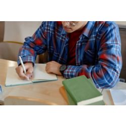 Male teen writing in notebook