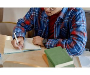 Male teen writing in notebook