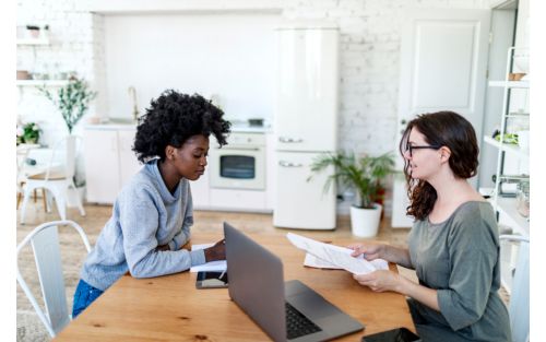 photo of two women working together