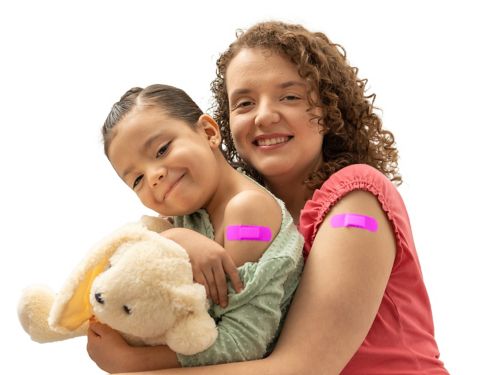 mother and daughter with pink band aid smiling after having an injection