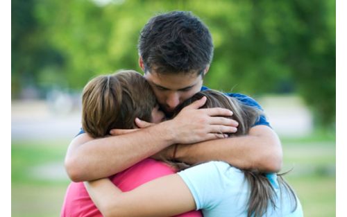 Father hugging two children protectively