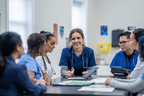 A small group of medical professionals gather around a table