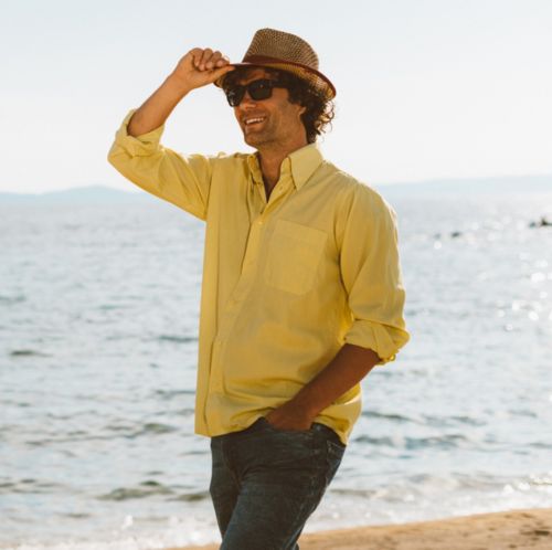 Man walking on beach in long sleeved shirt