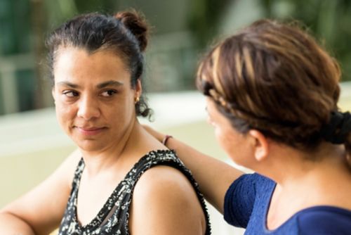 Woman with hand on shoulder of grieving friend