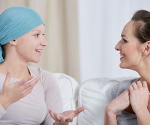 Young cancer woman wearing headscarf, talking with friend