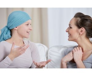 Young cancer woman wearing headscarf, talking with friend