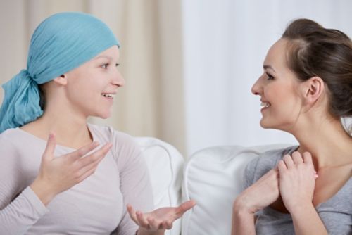 Young cancer woman wearing headscarf, talking with friend