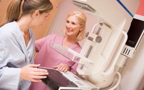 stock photo of woman talking to nurse before getting a mammogram