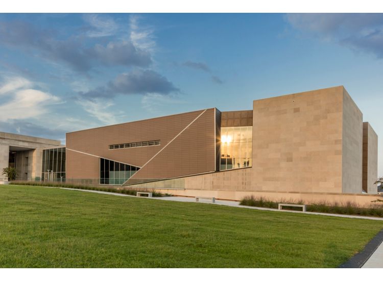 photo of exterior of building. sunlight glints off one of the windows