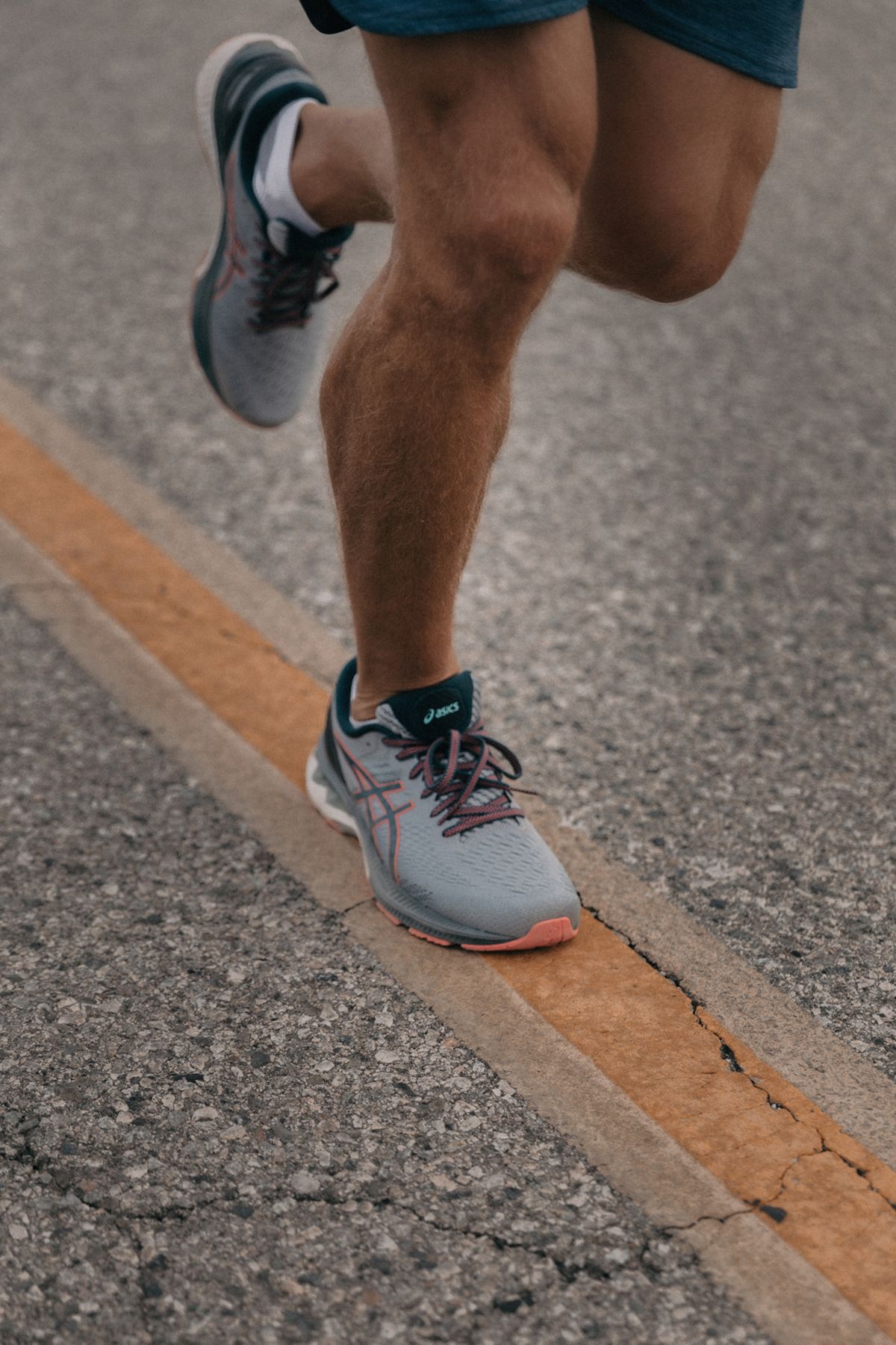 Man's legs while running on road