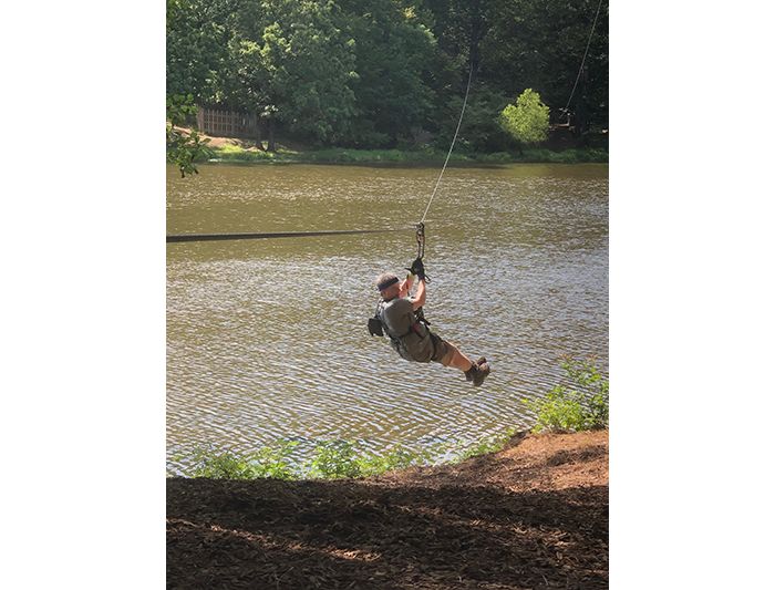 Kriwacki lab member does rope course over lake at Shelby Farms