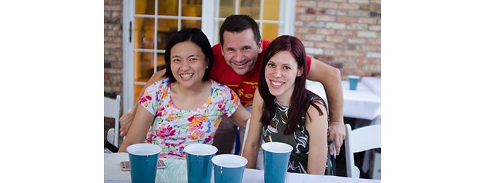 Three lab members pose together at party