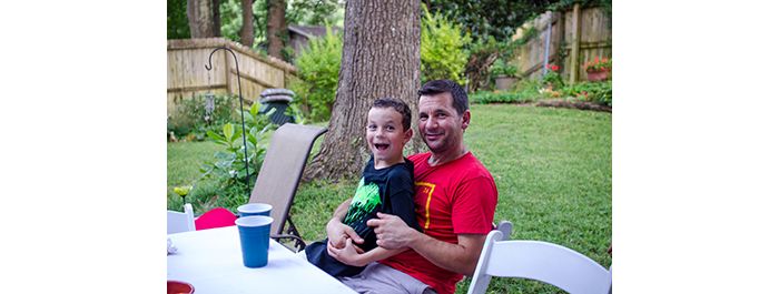 Lab member sits with young son at party