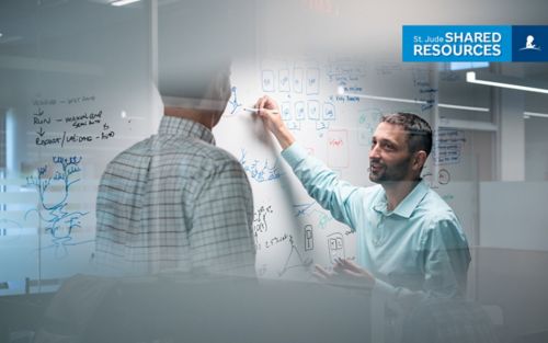 two men working at a whiteboard