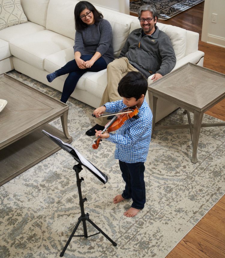 photo of Madan Babu and wife watching son play violin