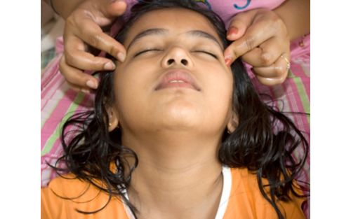 Child getting head massage from mother